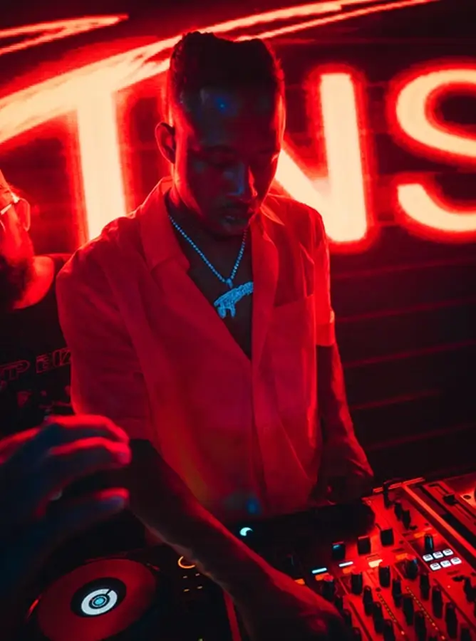 DJ mixing in red light at Sapphire New York SINS, showcasing music and party energy at the gentleman’s club.